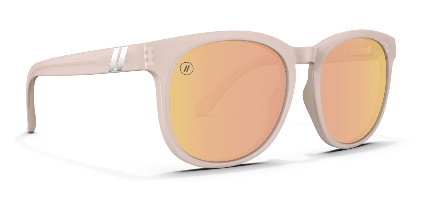 A close up, angled view of the front and right side of the Pink Rose Blenders Sunglasses showcasing the glossed milky pink frame and polarized PureBlend™ pink mirrored lenses of the sunglasses.