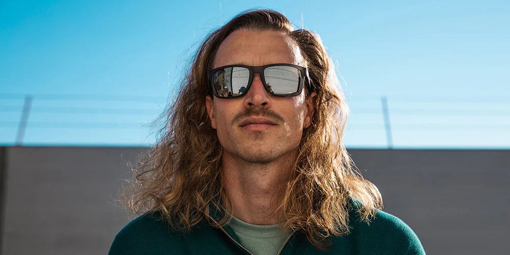 A close up front view image of a man looking straight wearing the Sterling Smoke Chaser Sunglasses, showcasing a front view of the matte-finished crystal black frame and polarized PureBlend™ silver mirrored lenses of the sunglasses.