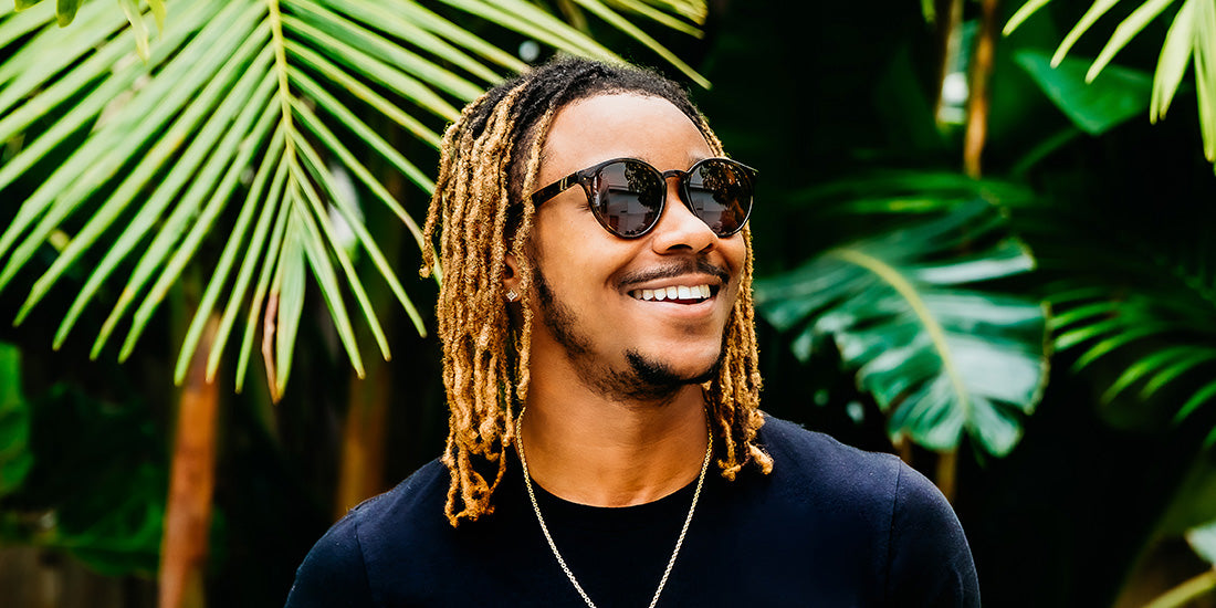 A close up, image of a man in a black shirt wearing the Tort Blenders Sunglasses, showcasing a front, left side view of the gloss tan tortoise frame and polarized PureBlend™ amber lenses of the sunglasses.